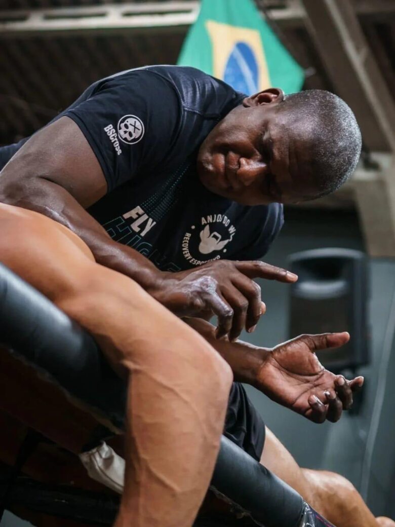 Carlos André aplicando terapia manual na perna de um atleta